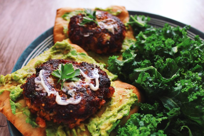 Salmon burgers on avocado flatbread toast with a kale salad